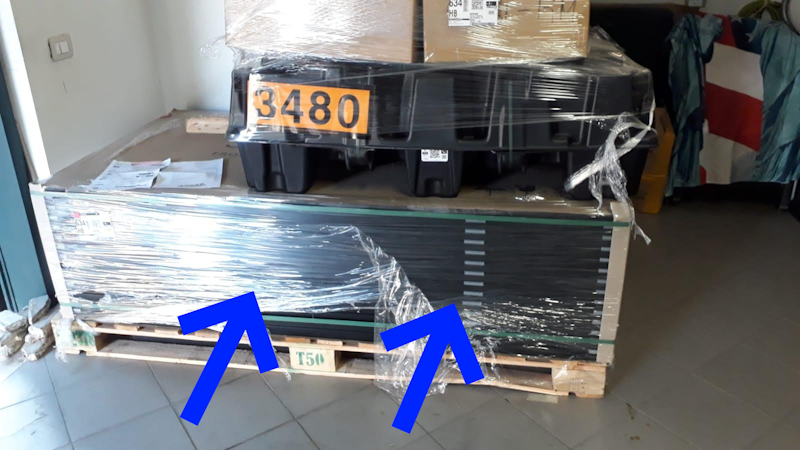 Movimentazione del bancale con il transpallet, lance inserite nella parte centrale, poggiato a terra davanti al box.