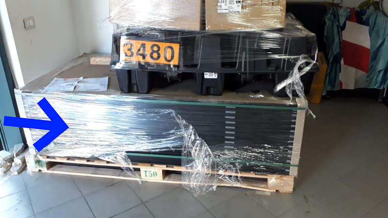 Sollevamento asimmetrico del bancale: il transpallet è inserito dal lato opposto alla batteria Tesla Powerwall 3, causando una flessione del legno sotto il peso concentrato.